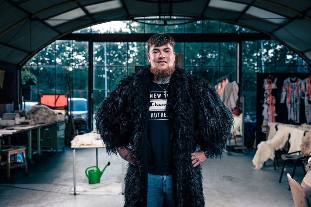 SDG held Mats Eisma in een zwarte bontjas. Poserend recht voor de camera in het atelier van Colien.